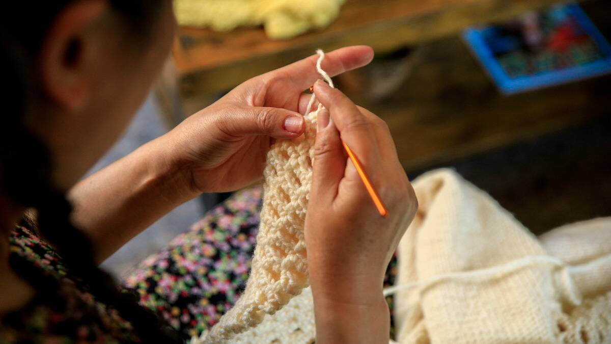 A close, over-the-shoulder shot of someone crocheting.