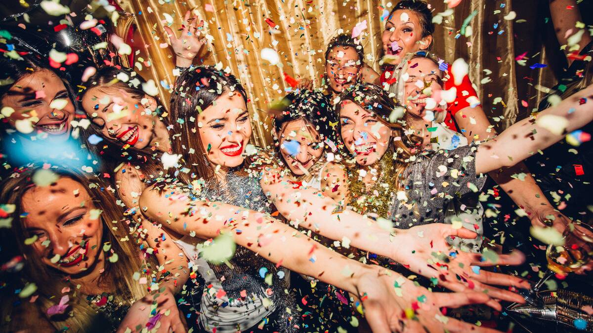 A group of friends at a party, confetti raining down on them.