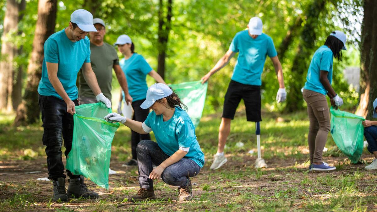 A group of volunteers picking up garbage in a park.