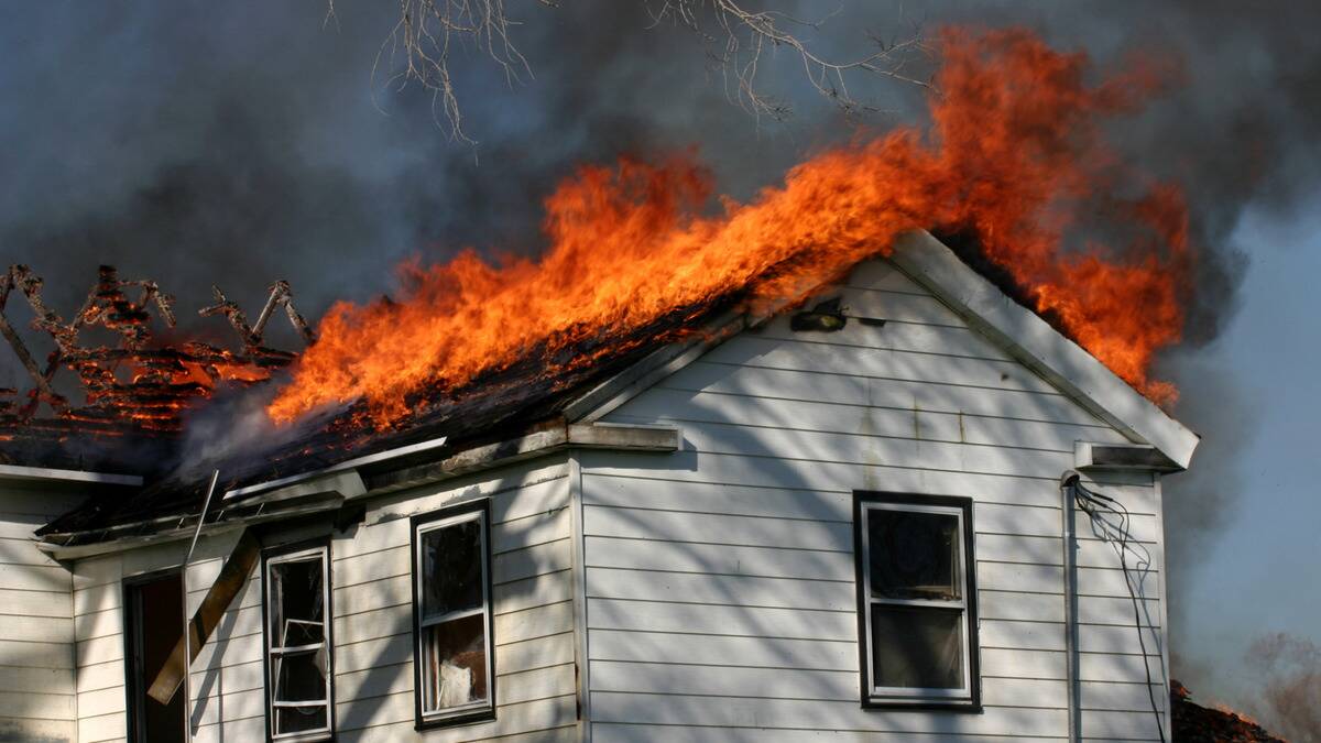 A photo of a house's roof on fire.