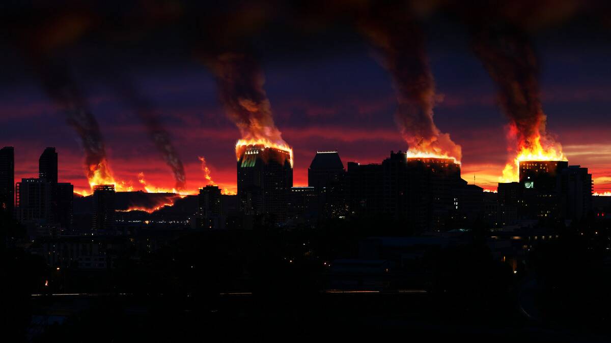 A city skyline in which the tops of quite a few buildings are on fire.