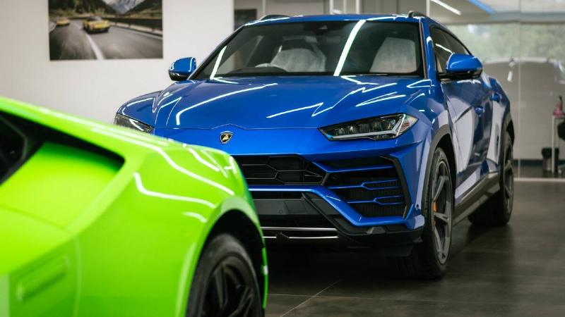 A fancy, shiny blue SUV in a dealership.