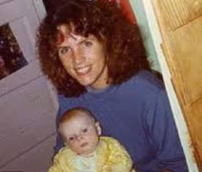 Baby Carter with his mother, who's smiling as she holds him in her lap.