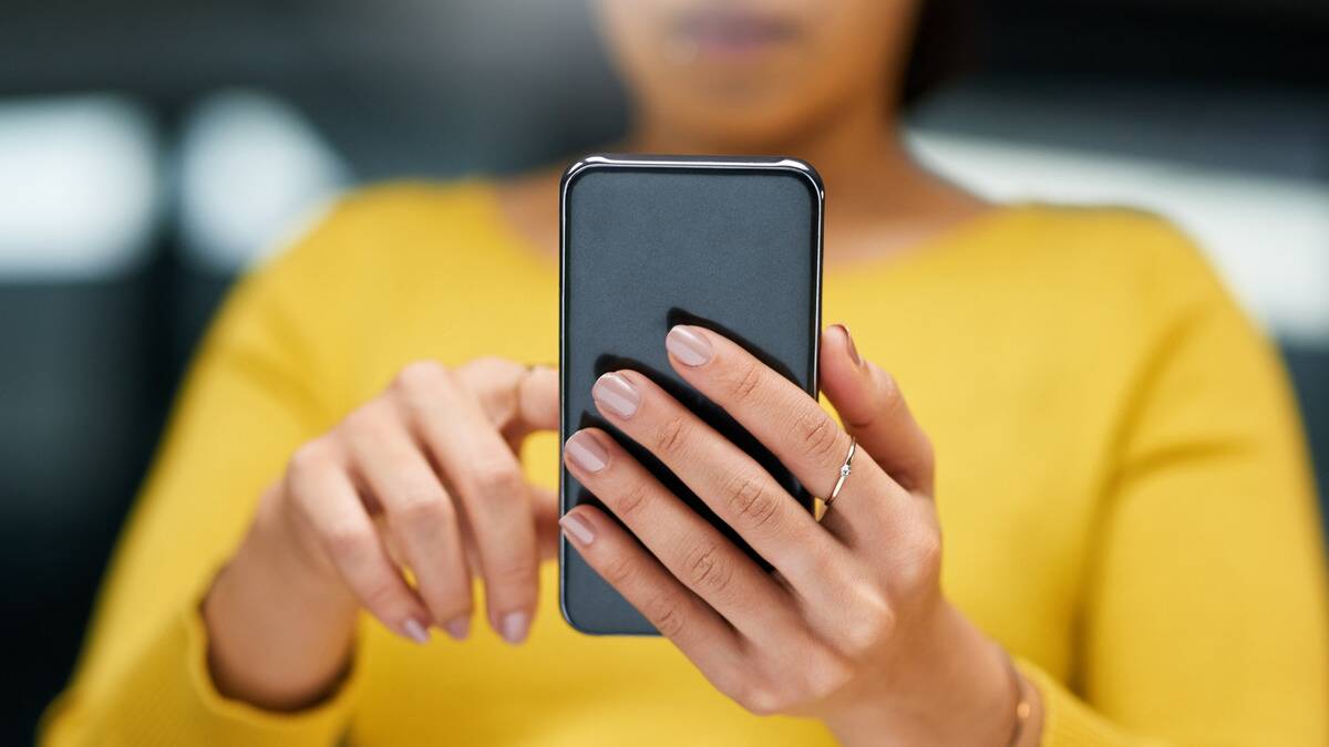 A close photo of a woman scrolling through her phone.