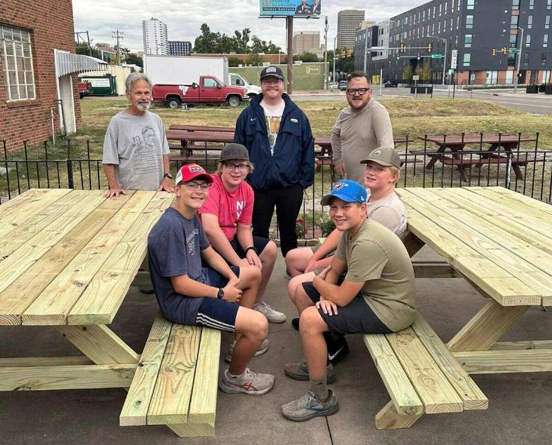 Starnes and his team sitting on two of the new tables they just finished building.