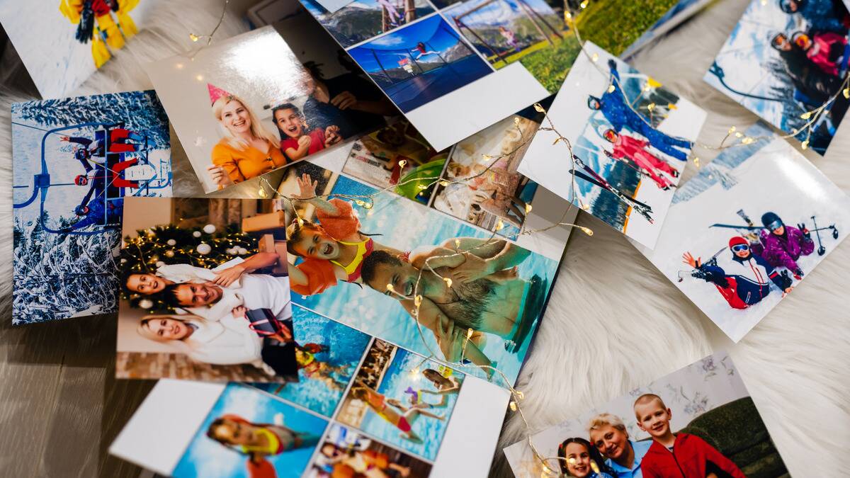 Someone's childhood photos scattered atop a blanket, fairy lights strung between them.