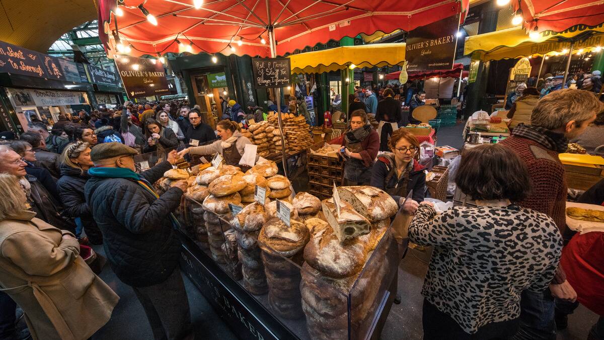 A bakery stand at a busy street market.