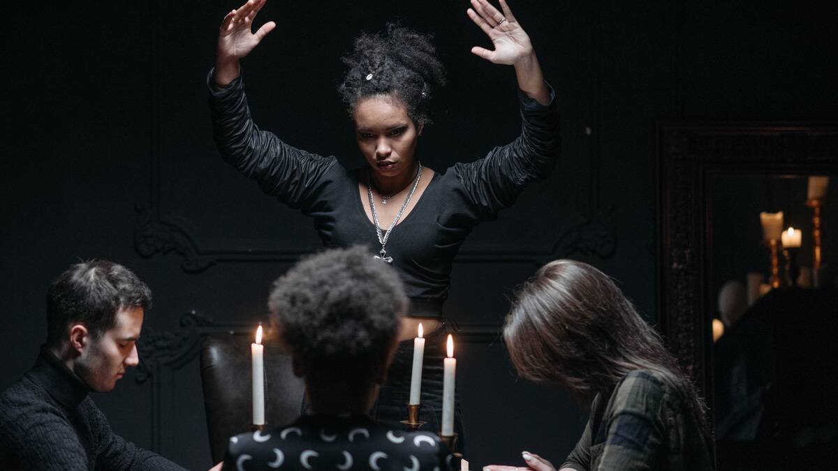 A woman standing as she leads a seance.