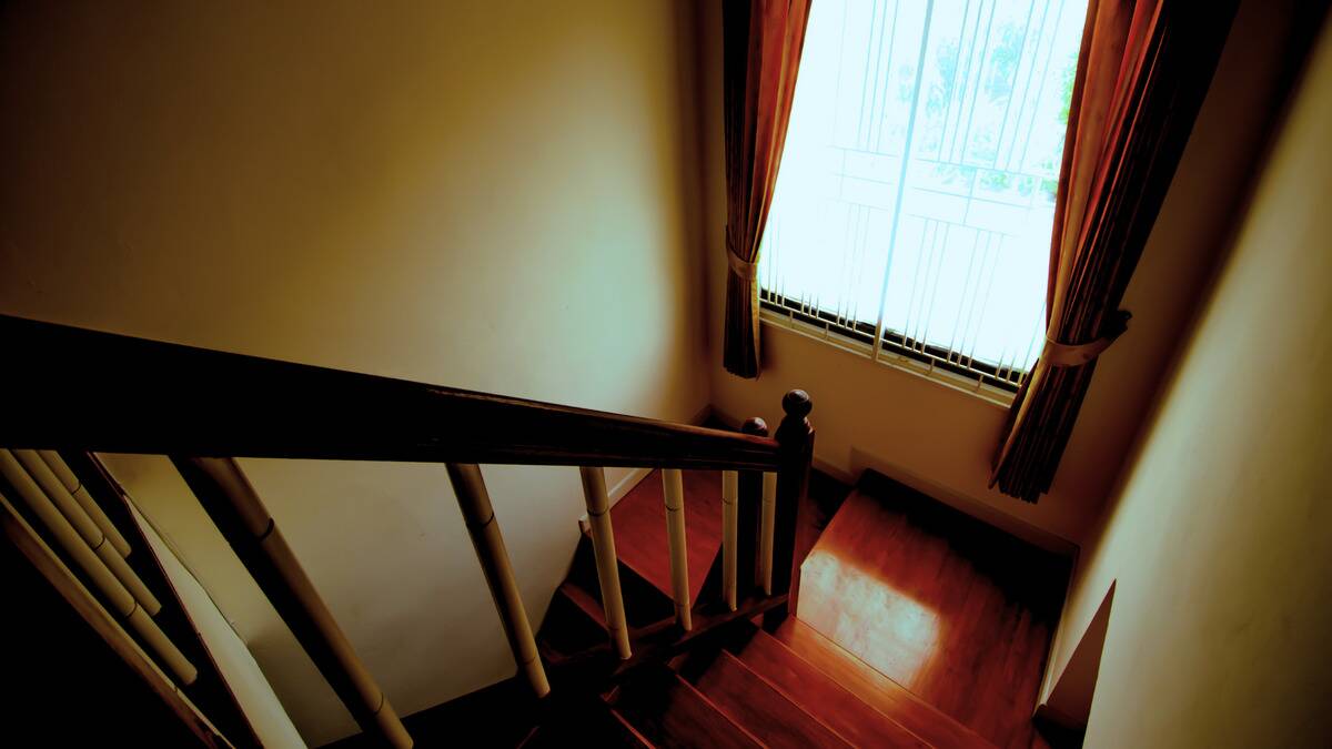 A darkly lit stairwell with a large window.