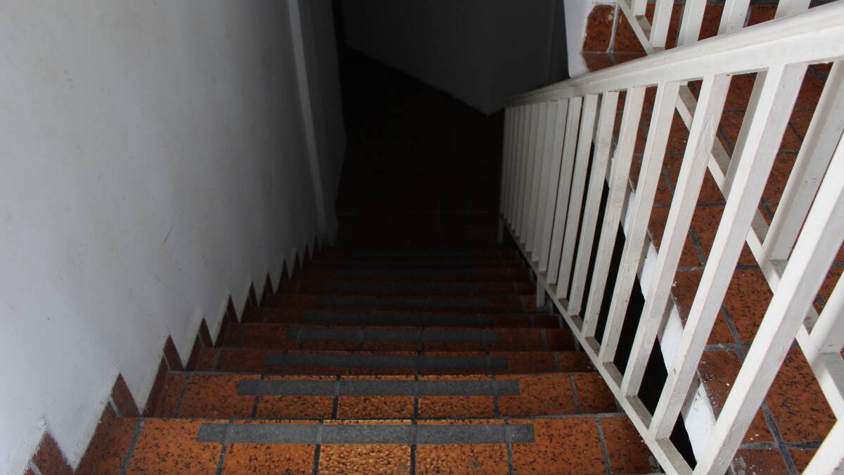 A staircase leading down, the bottom completely dark.