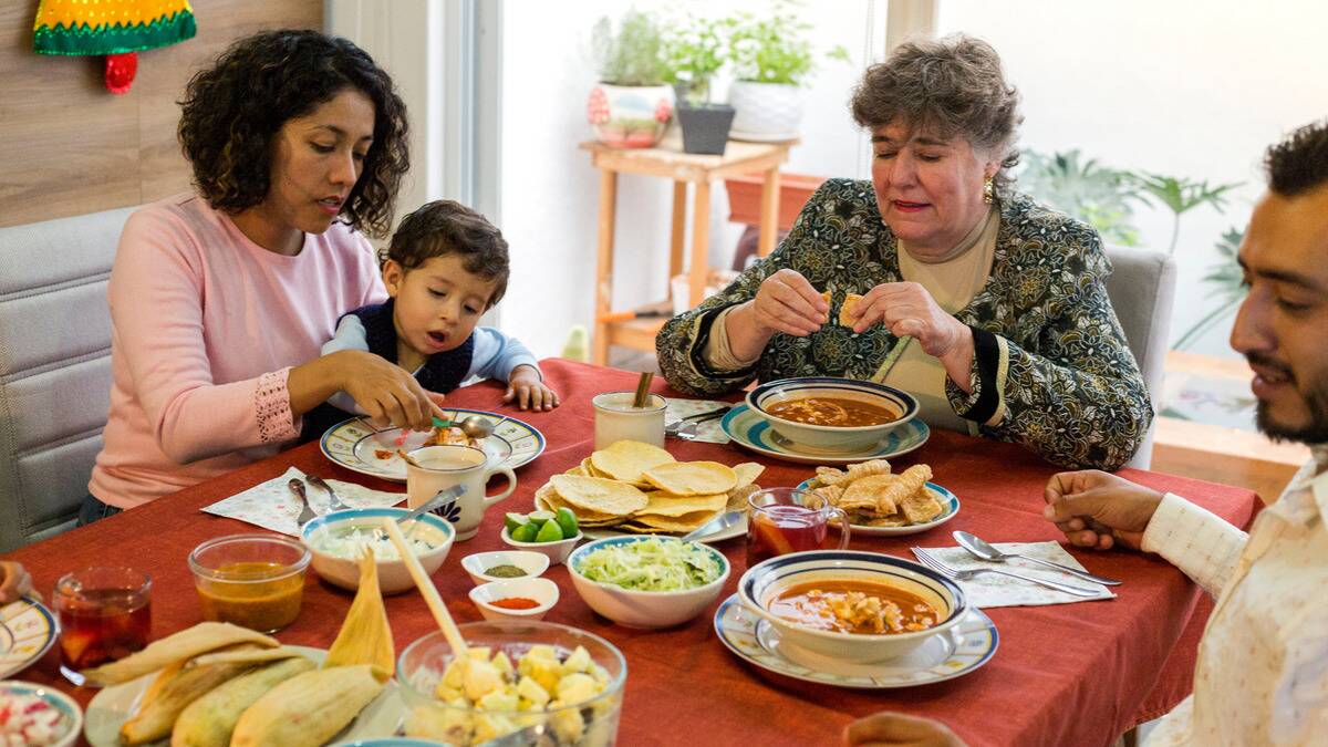 Three generations of family sat around a dinner table together.