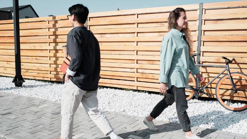 Two people walking past each other on the street.