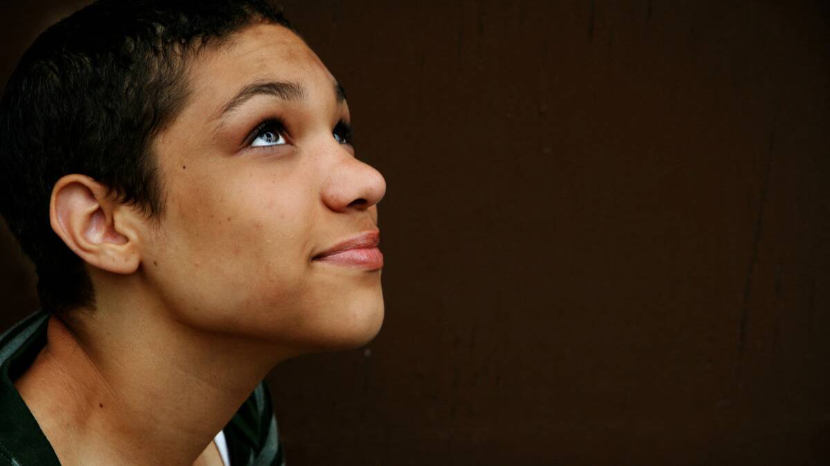 A woman looking upward with a hopeful expression on her face.