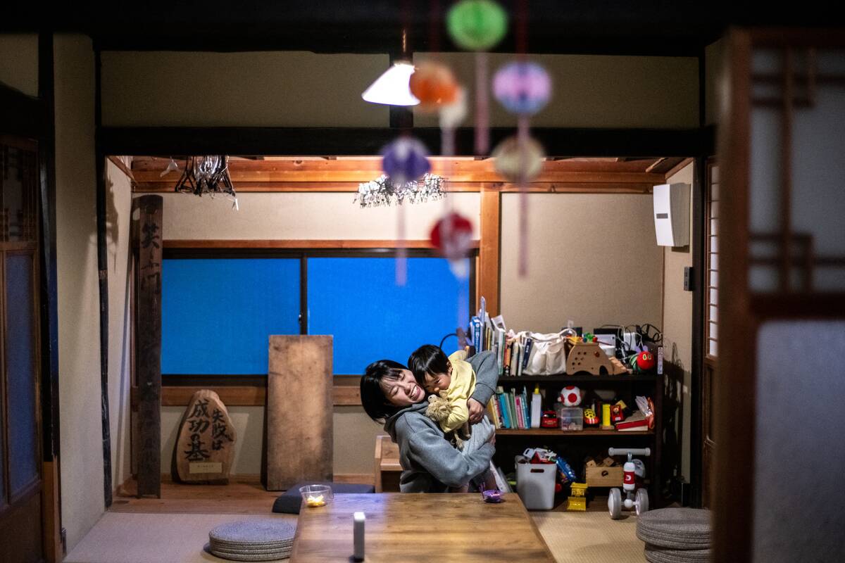 This photo taken on October 20, 2024 shows Rie Kato playing with her son Kuranosuke in their house in the village of Ichinono in the city of Tamba-Sasayama, Hyogo Prefecture.