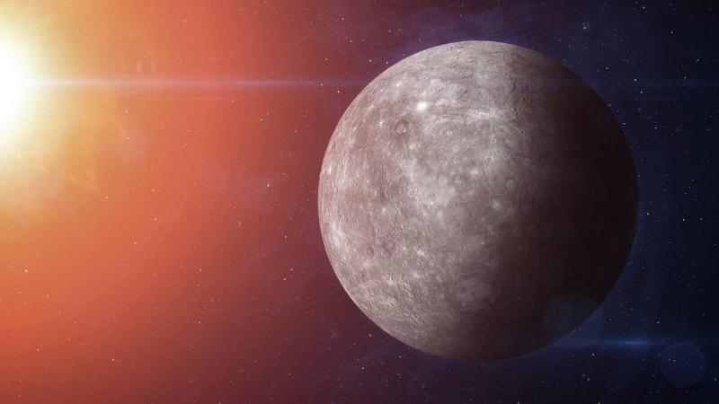 A render of planet Mercury in space, near the glowing light of the sun.