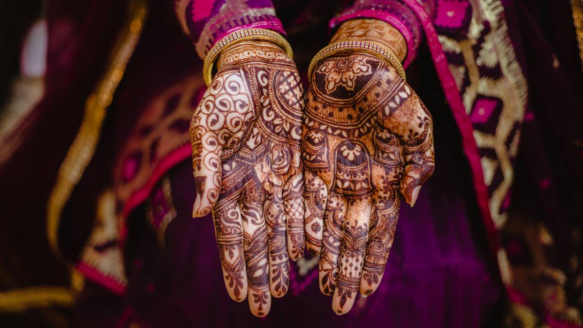 A woman's palms covered in detailed henna.