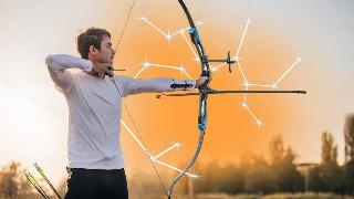 A man drawing an arrow back in a bow. There's orange smoke behind him and a graphic of the Sagittarius constellation.