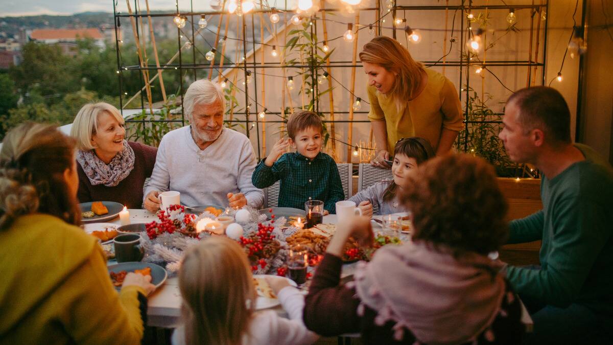 A family gathered around an outdoor table for a holiday dinner.