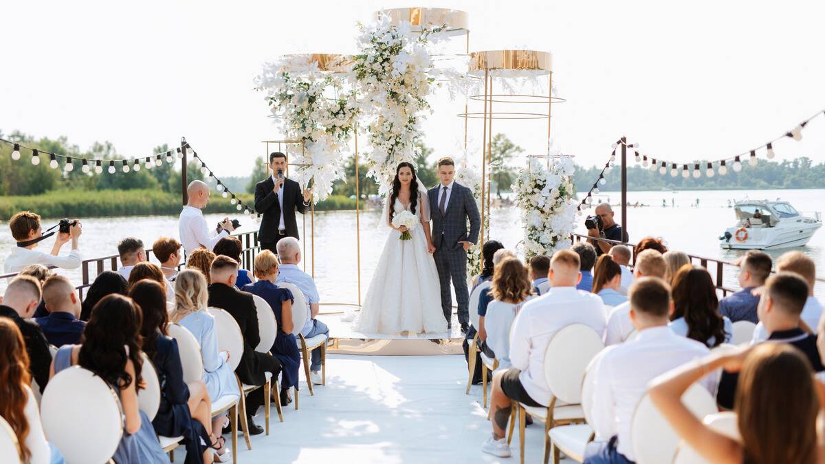 A couple standing at an extravagant altar for the ceremony of their outdoor wedding.