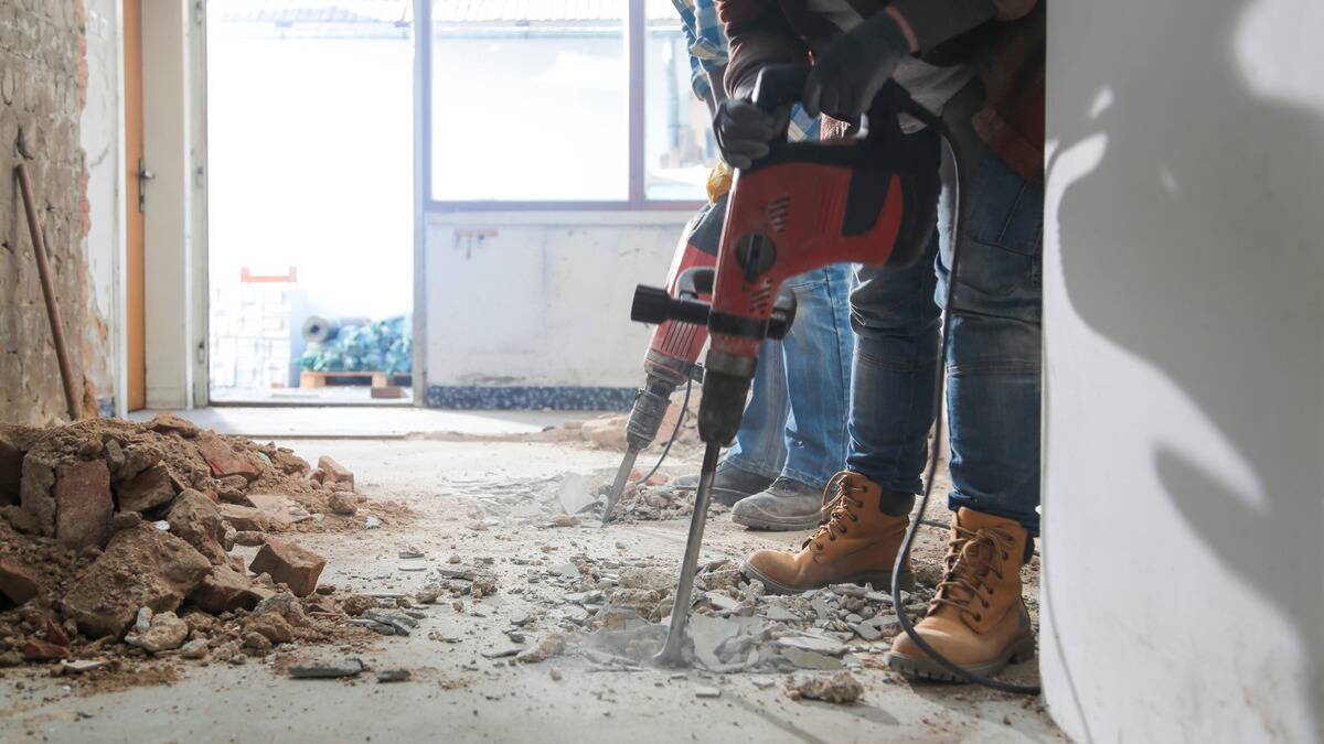 Two people using jackhammers to break up a concrete floor.