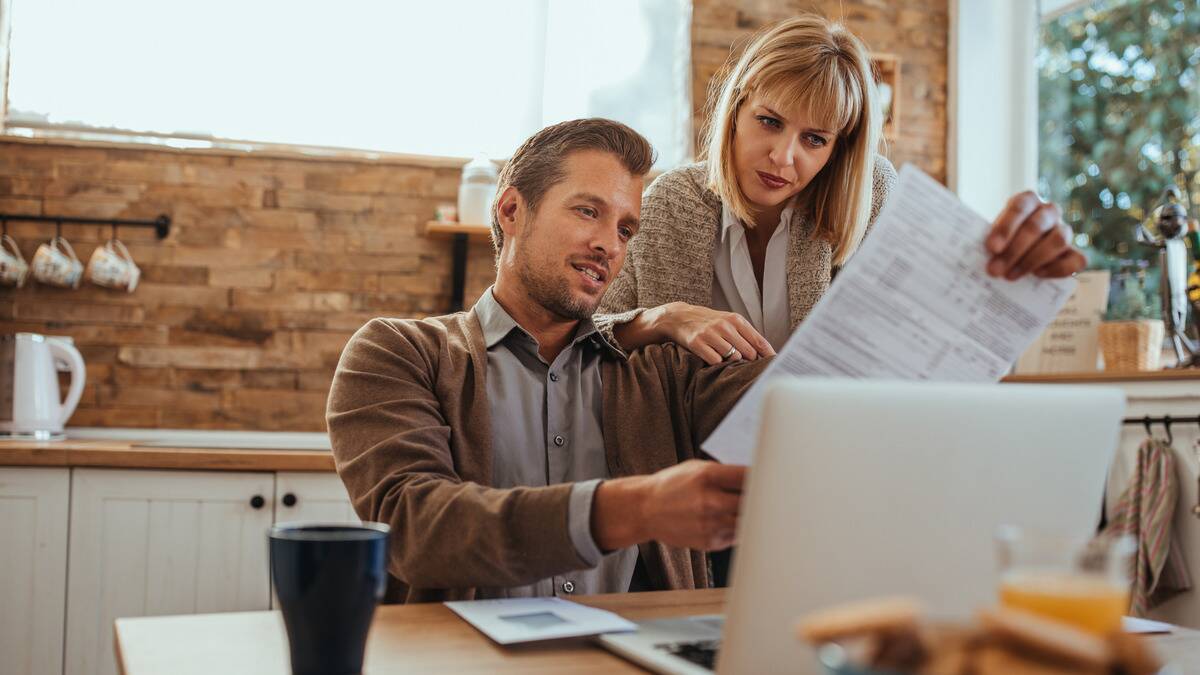 A couple looking over a financial form in their kitchen.