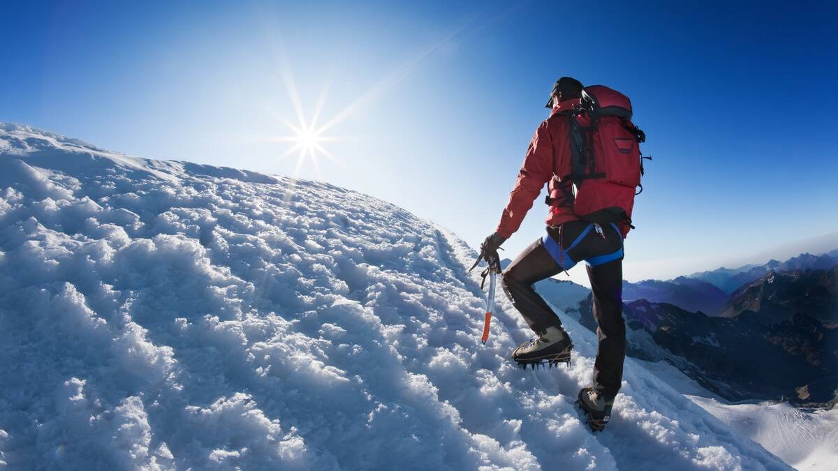 A man climbing a snowy hill.