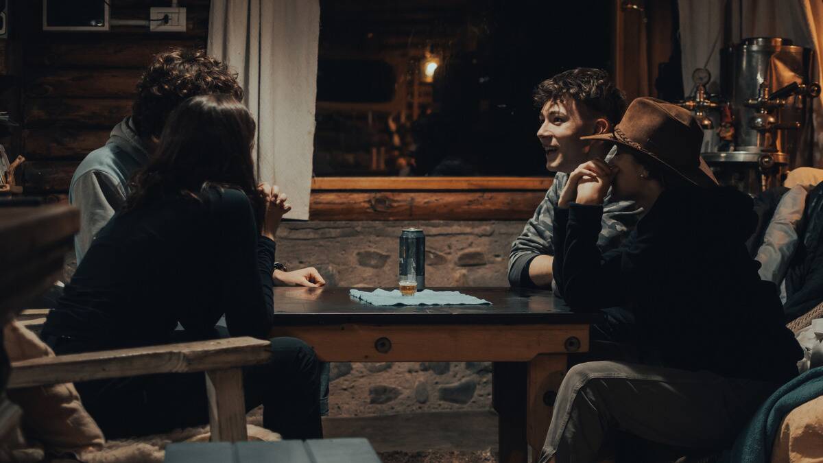 Four friends sitting around a table chatting.