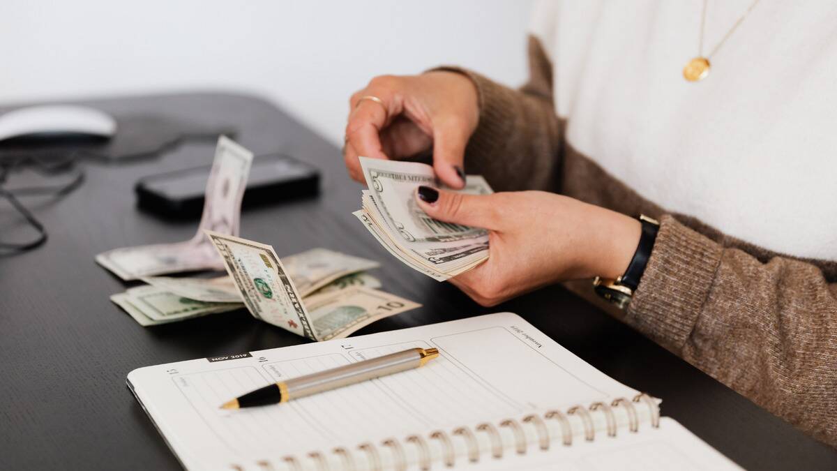 A close shot of someone counting a stack of bills.