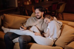 couple in sweats cuddling on couch