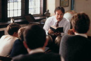 Robin Williams in Dead Poets Society, reading to students surrounding him