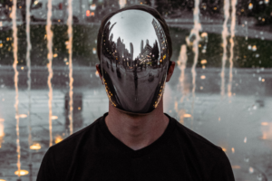 man with reflective face by night fountain