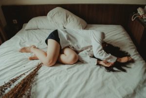 woman sleeps on bed with her hair covering her face