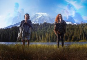 two people stand by mountain in prayer motion