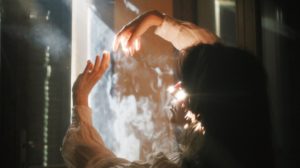 woman opening window full of smoke