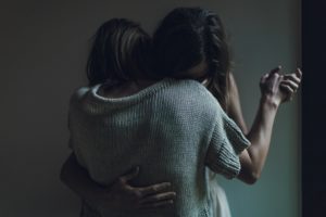 two people hug in darkness