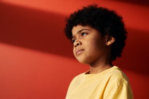 kid looks over by red background