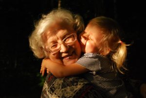 Little girl hugs her grandma as they both smile