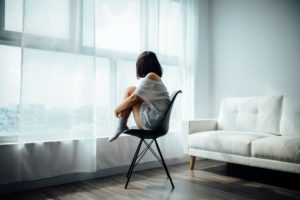 woman sitting on chair looking out the window