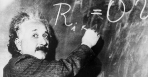 Theoretical physicist Albert Einstein writes a complicated equation on a blackboard. He is at the California Institute of Technology for a lecture being given by Swedish astronomer Dr. Gustave Stromberg.