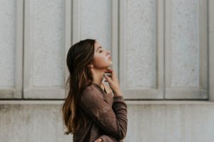 woman puts up her hand to her face