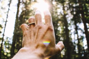 hand reaching for the light with rainbow