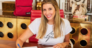 Sarah writing on desk and smiling for photo