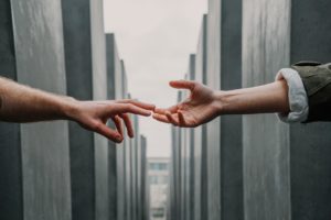 hands reaching for one another through wall seperation