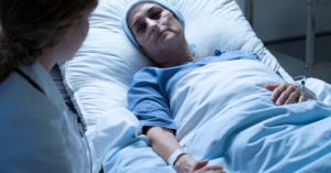 Dying woman holding hands with nurse