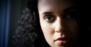 woman with green eye in window light